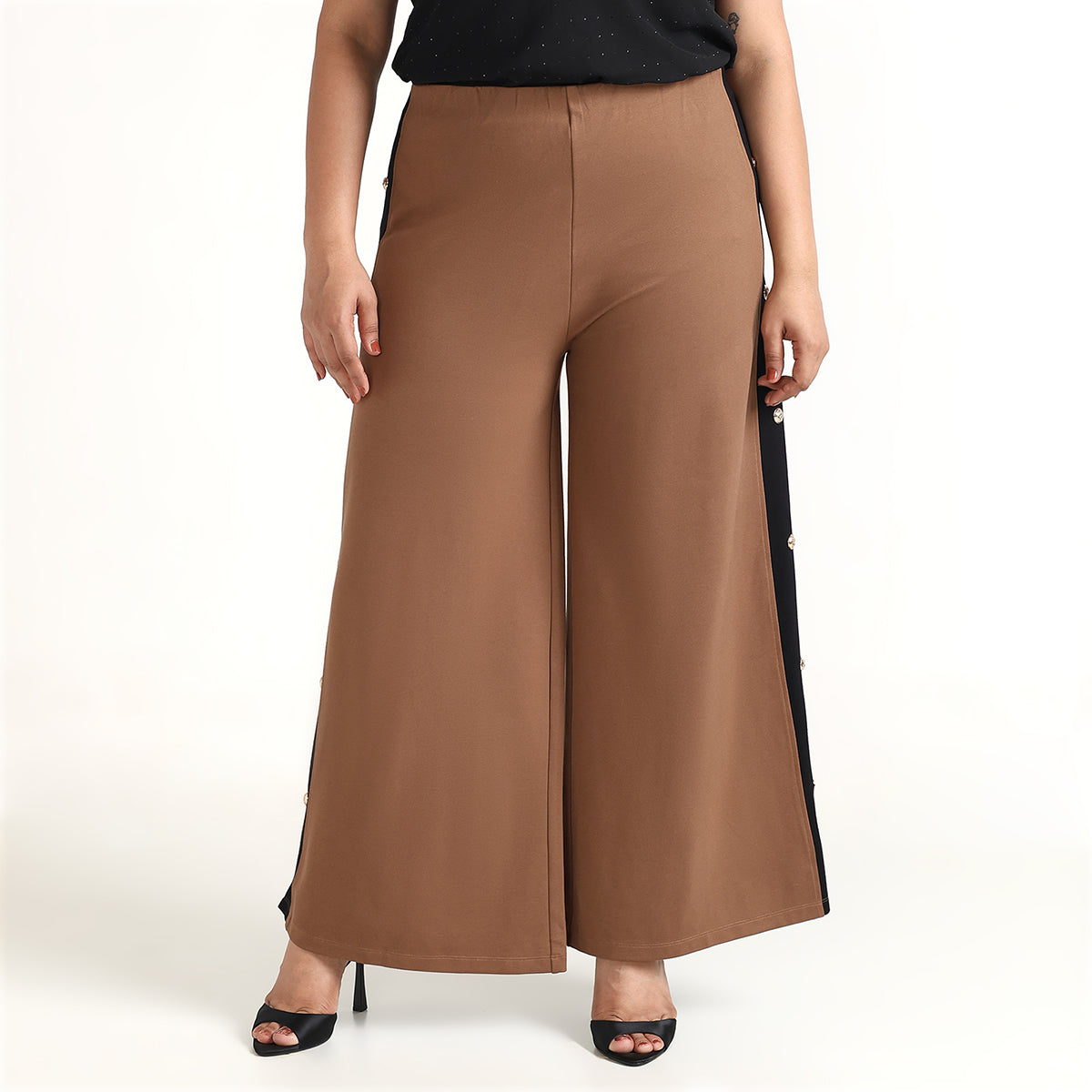 Brown wide-leg pants with black side stripes worn by a person on a white background