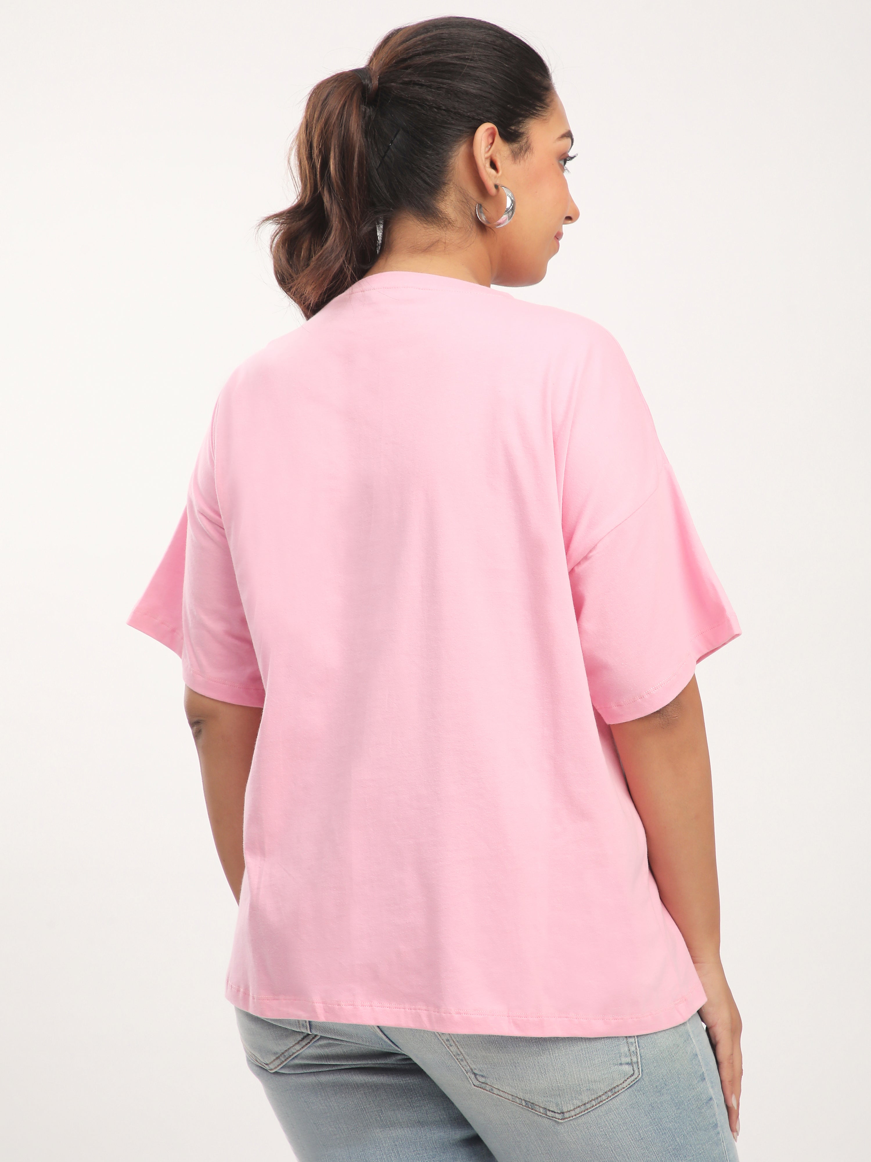Person wearing a pink t-shirt and jeans on a white background