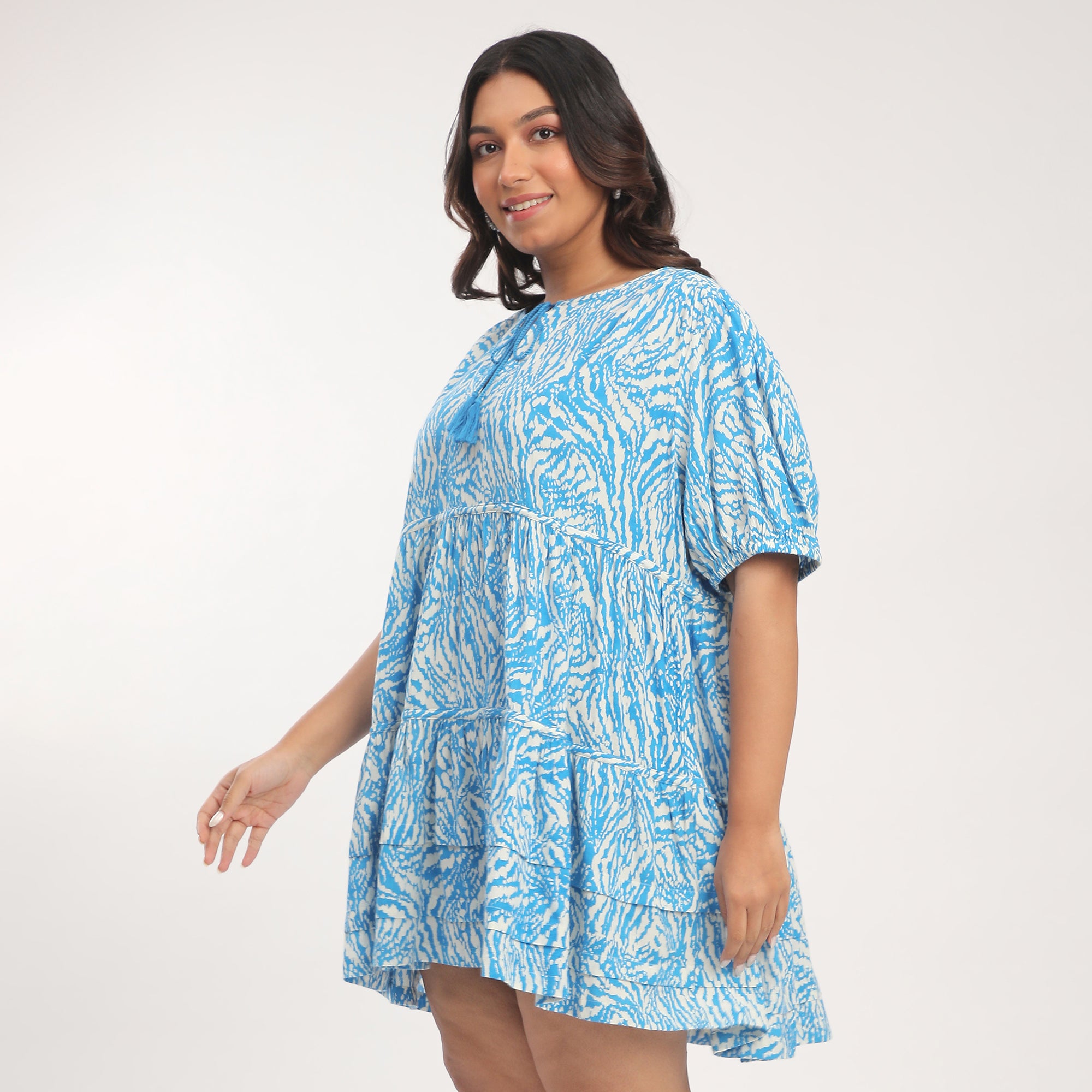 Woman wearing a blue patterned dress on a white background