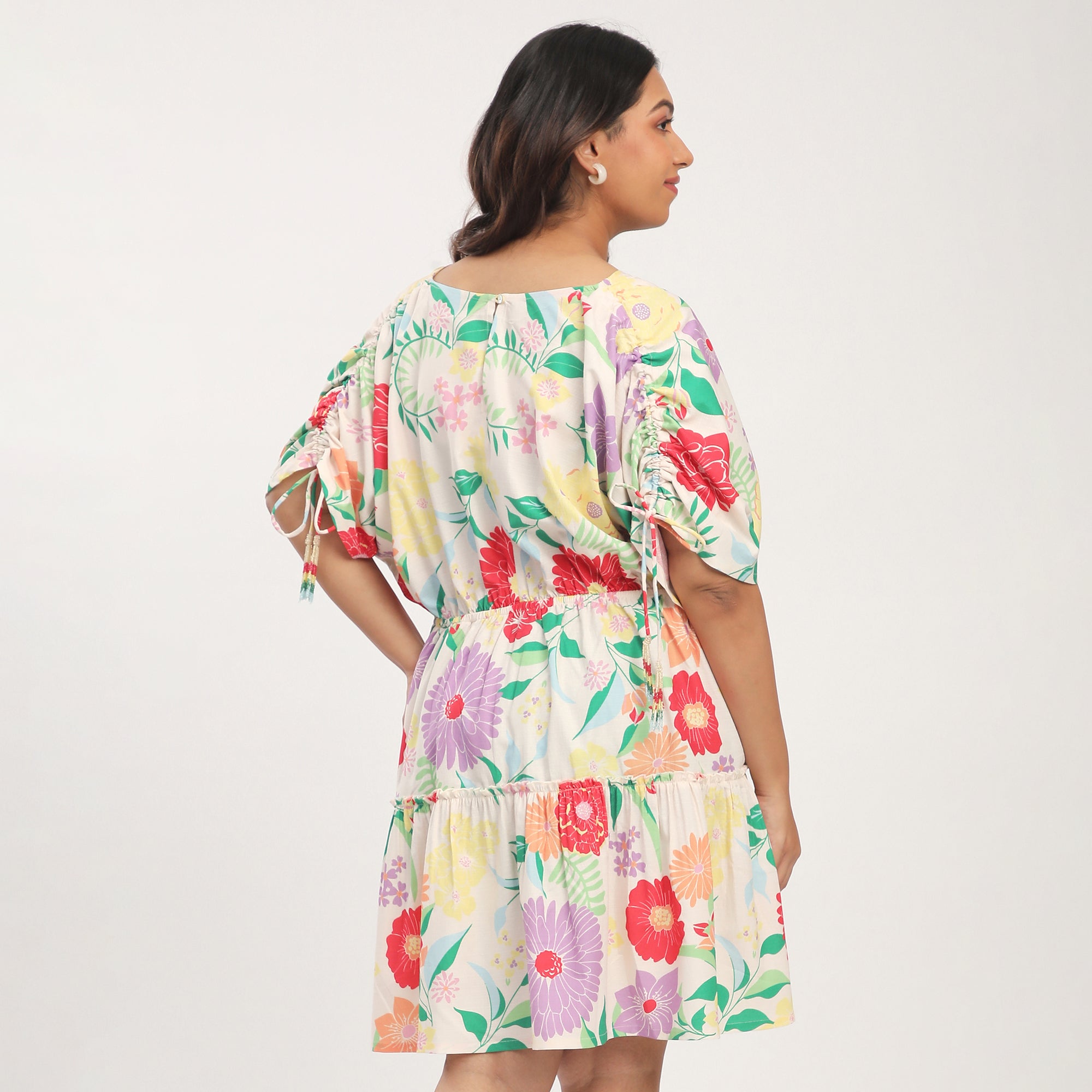 Woman wearing a floral printed dress on a plain background