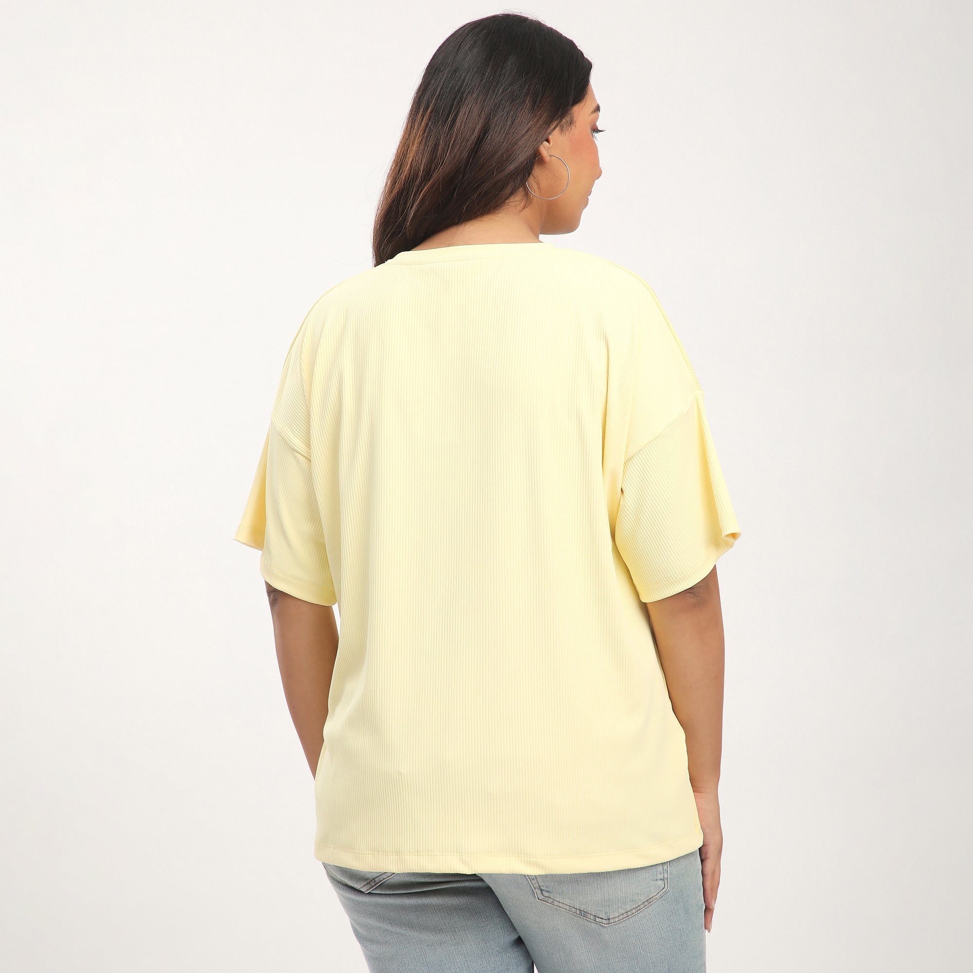 Person wearing a light yellow t-shirt on a plain background