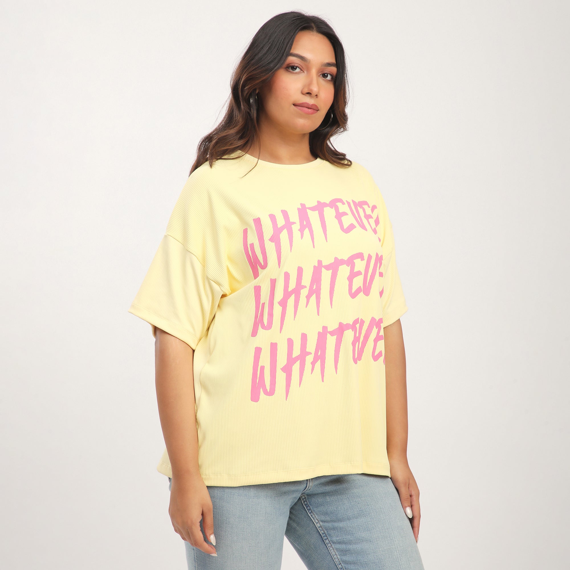 Woman wearing a yellow t-shirt with 'WHATEVER' text in pink.