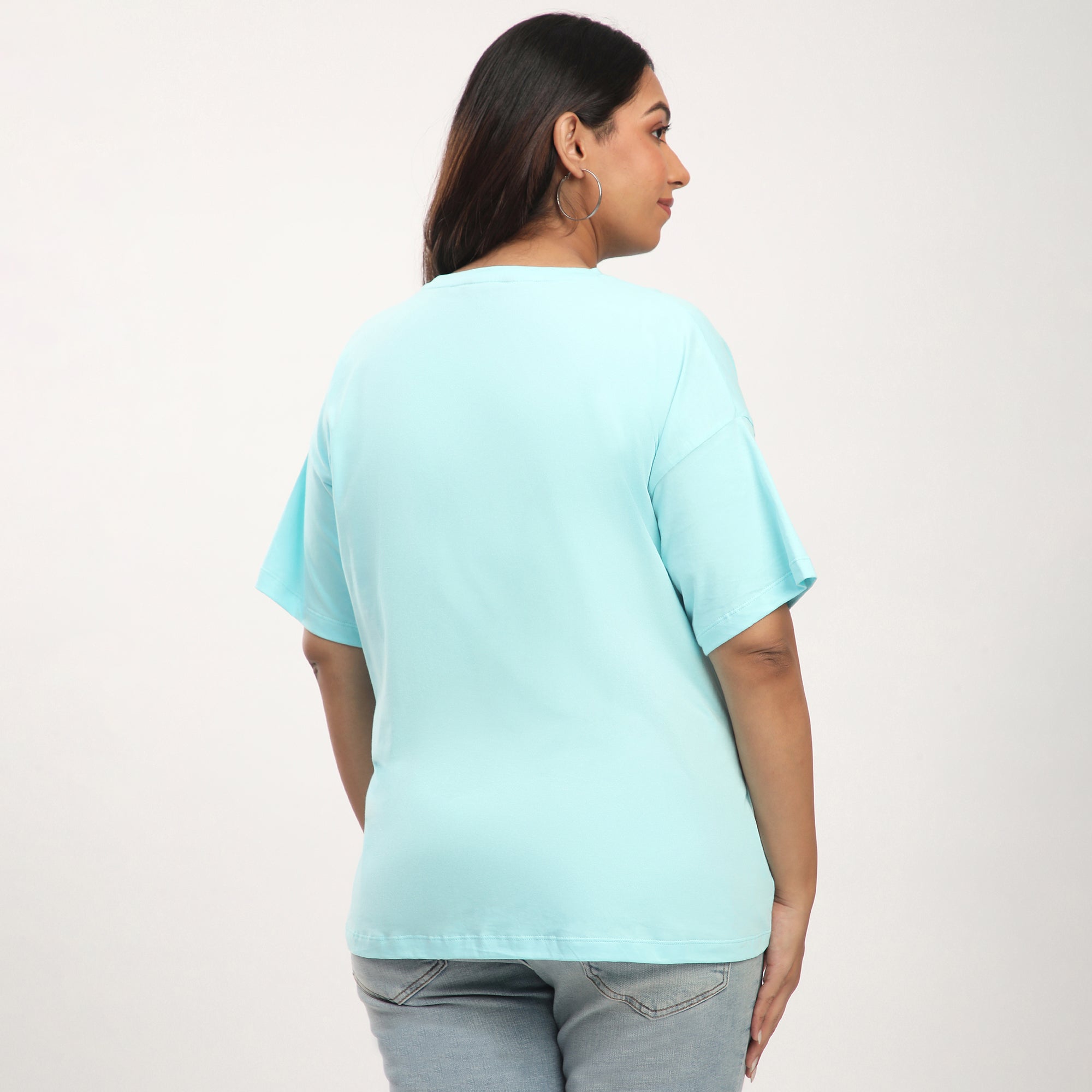 Person wearing a light blue t-shirt against a plain background