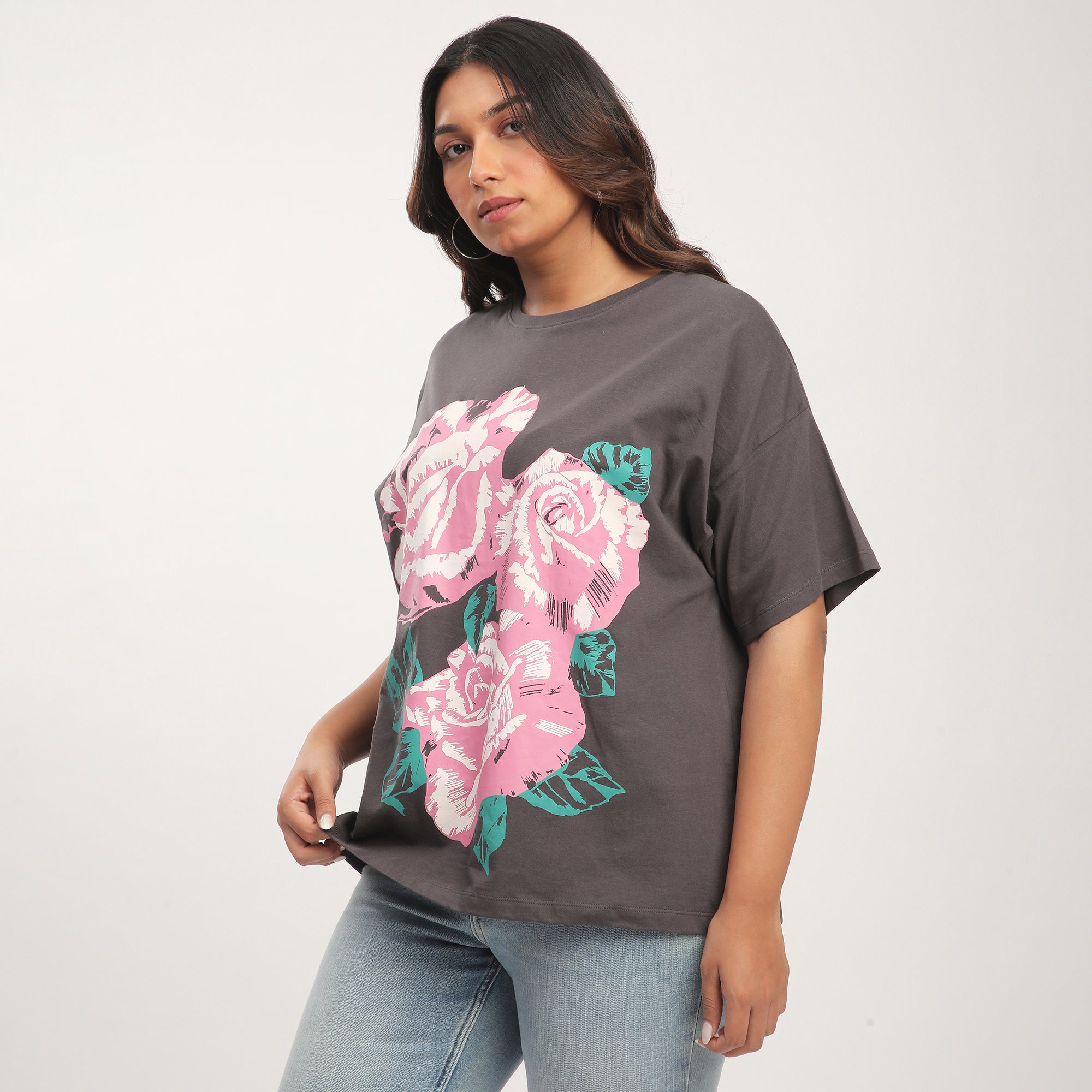 Woman wearing a gray t-shirt with pink rose design on a white background