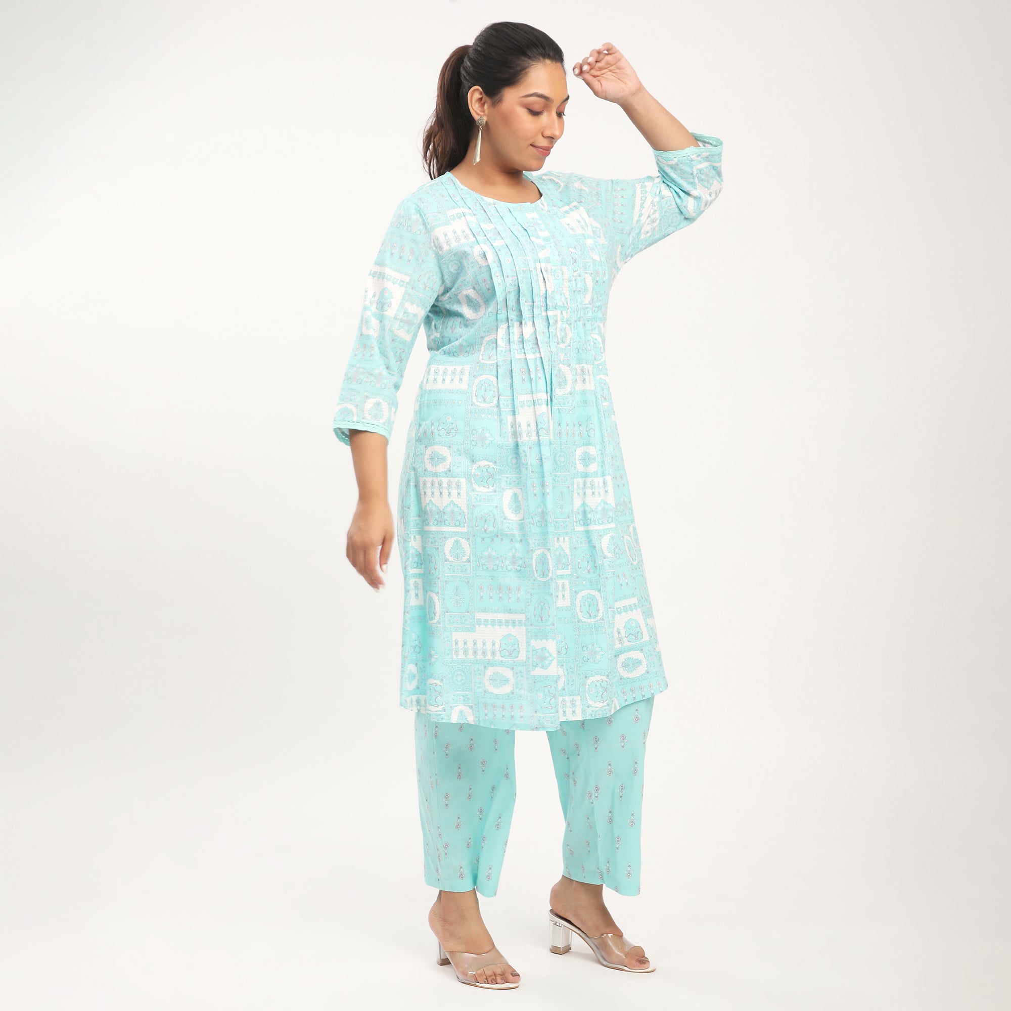Woman wearing a light blue kurta and pants on a plain background