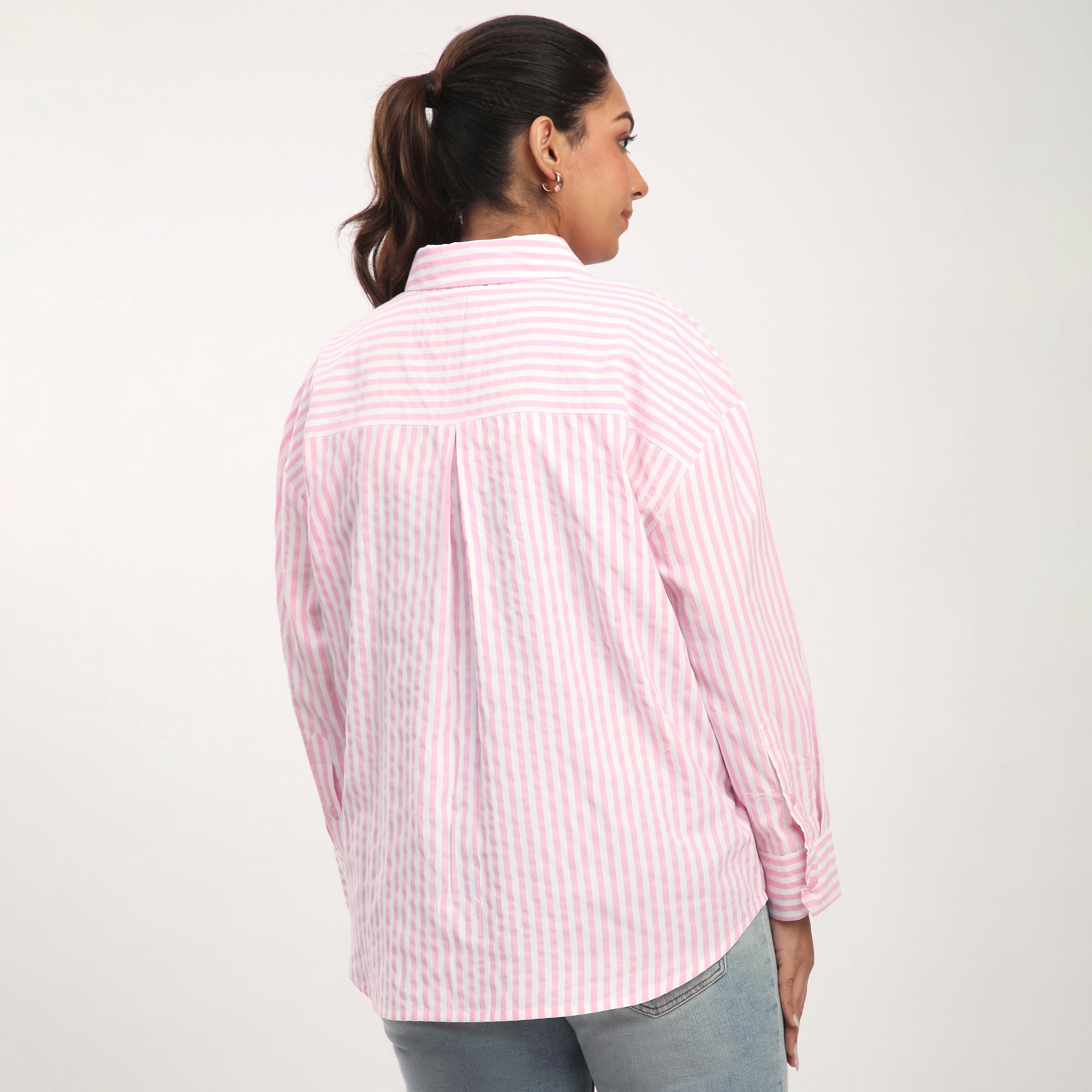 Person wearing a pink and white striped shirt against a plain background