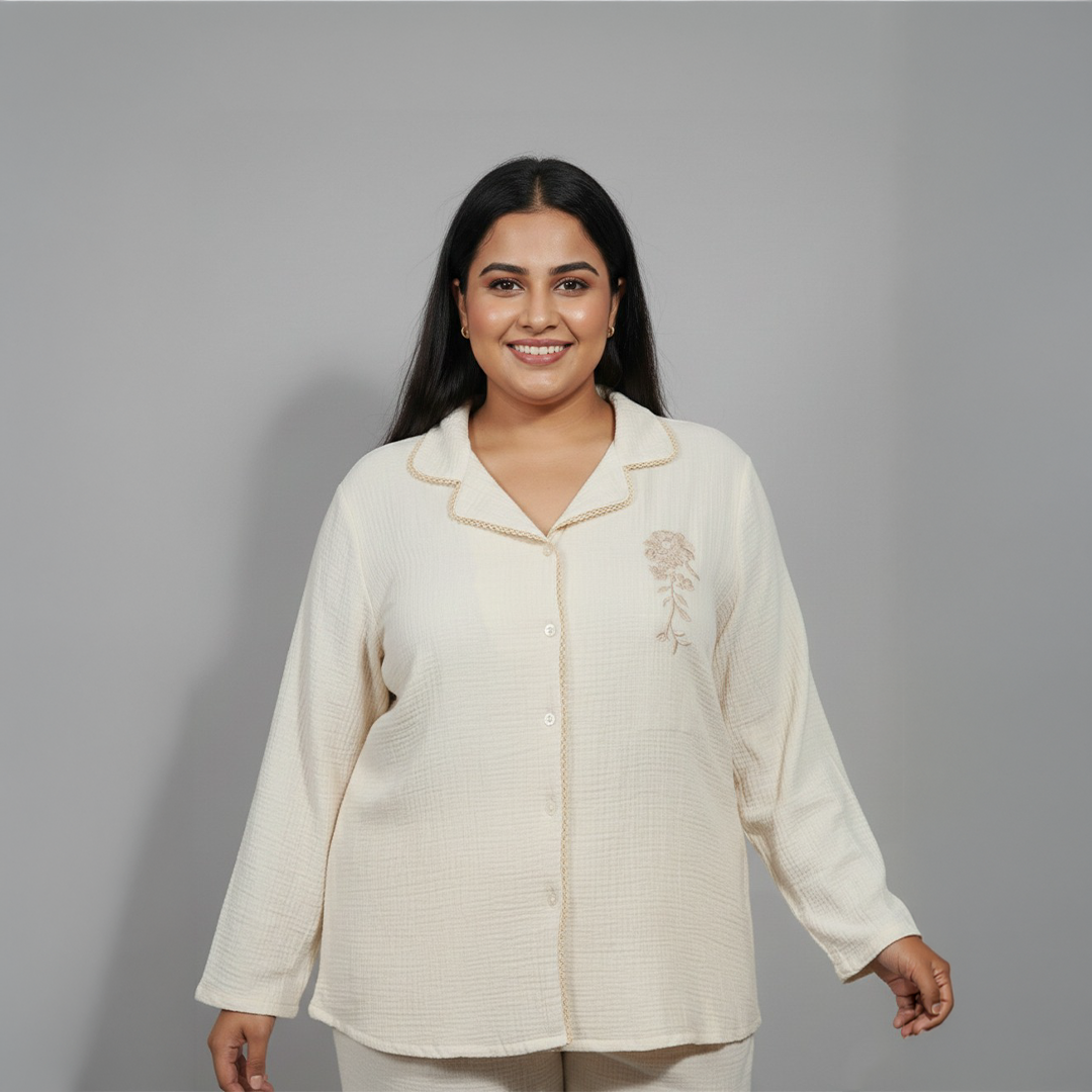 Woman wearing a cream-colored outfit with a floral design on a gray background