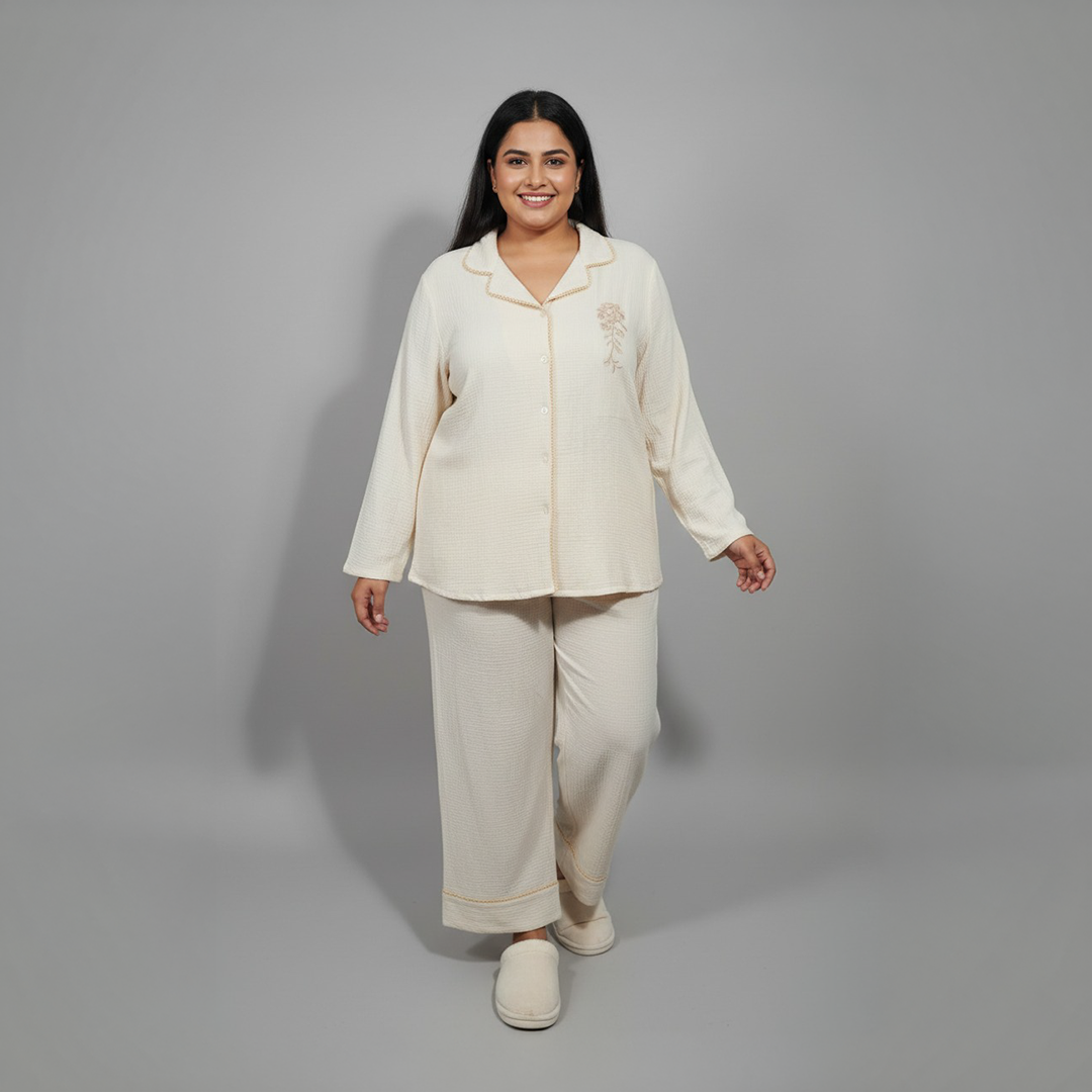 Woman wearing a cream-colored pajama set against a gray background