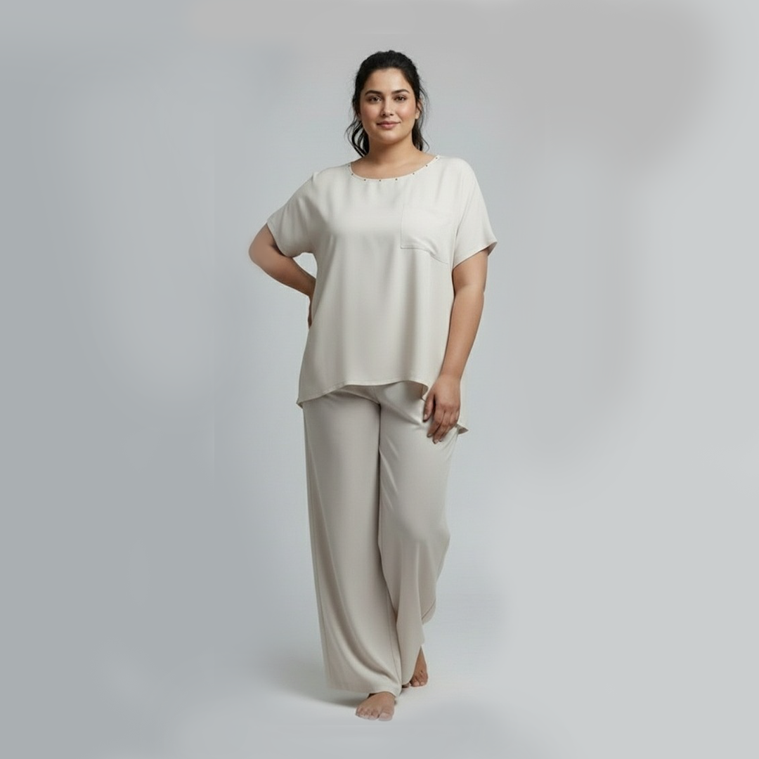 Woman wearing a beige pajama set on a plain background