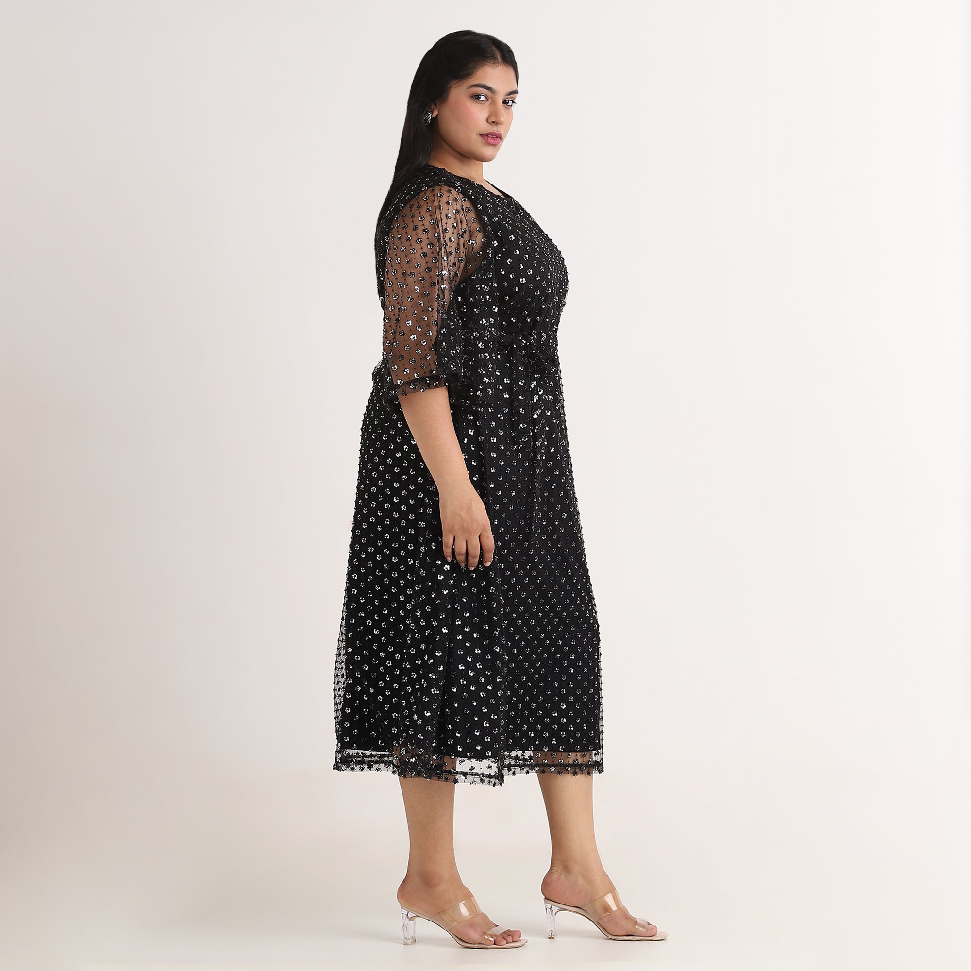 Woman wearing a black lace dress on a white background