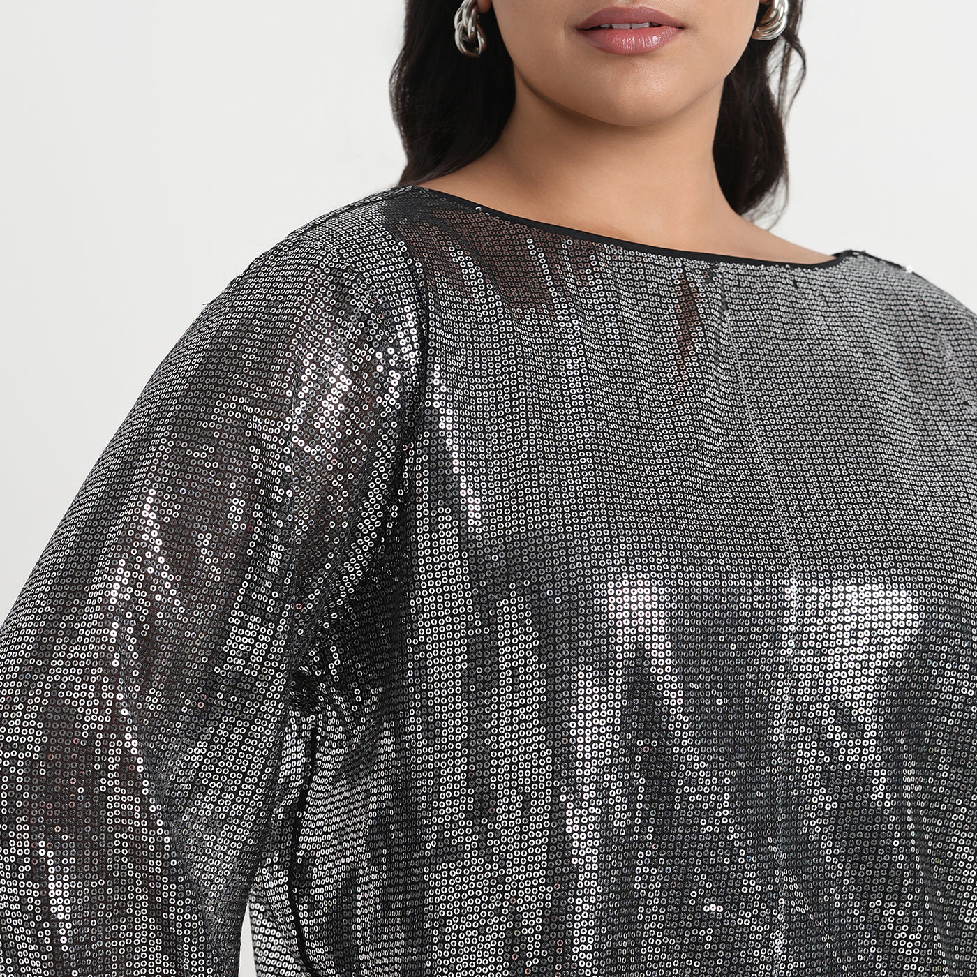 Silver sequin top with a shimmering finish, perfect for an elegant and festive look.
