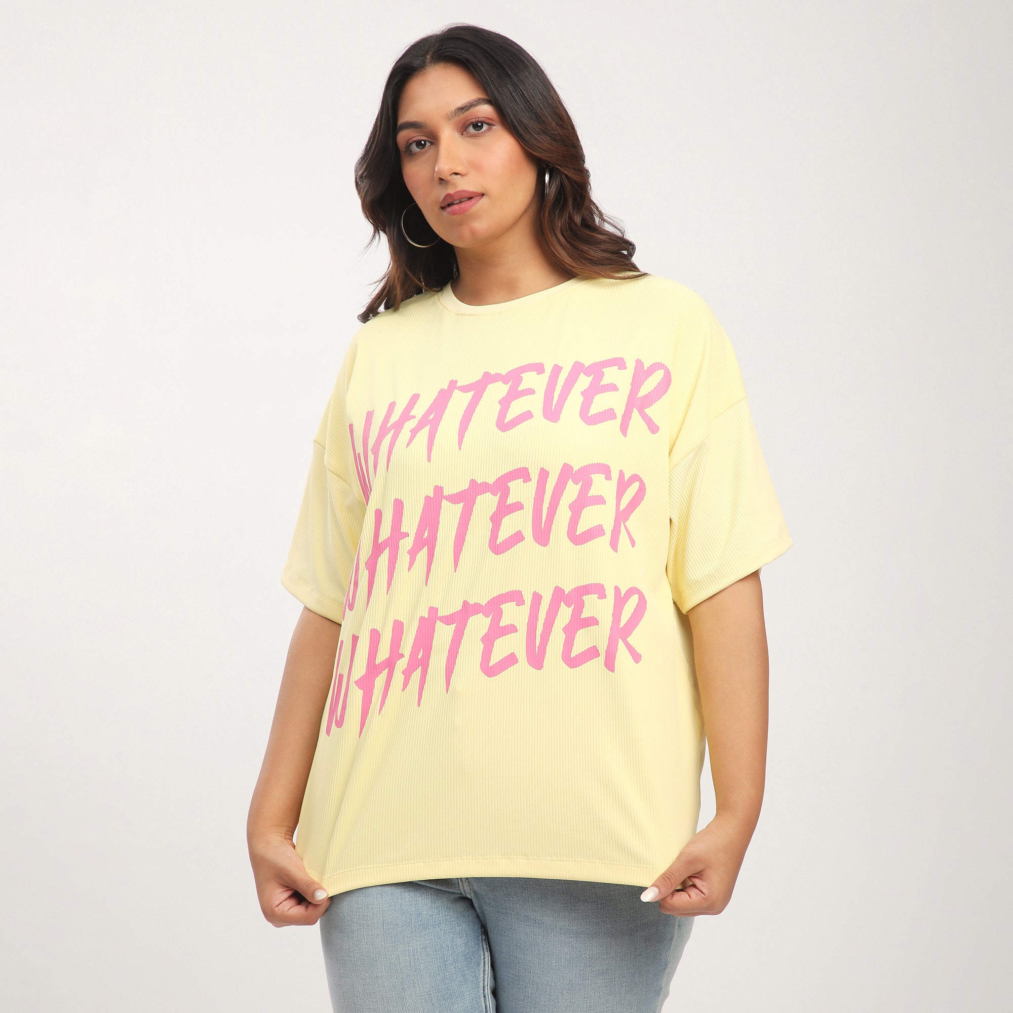 Woman wearing a yellow t-shirt with 'WHATEVER' text in pink.