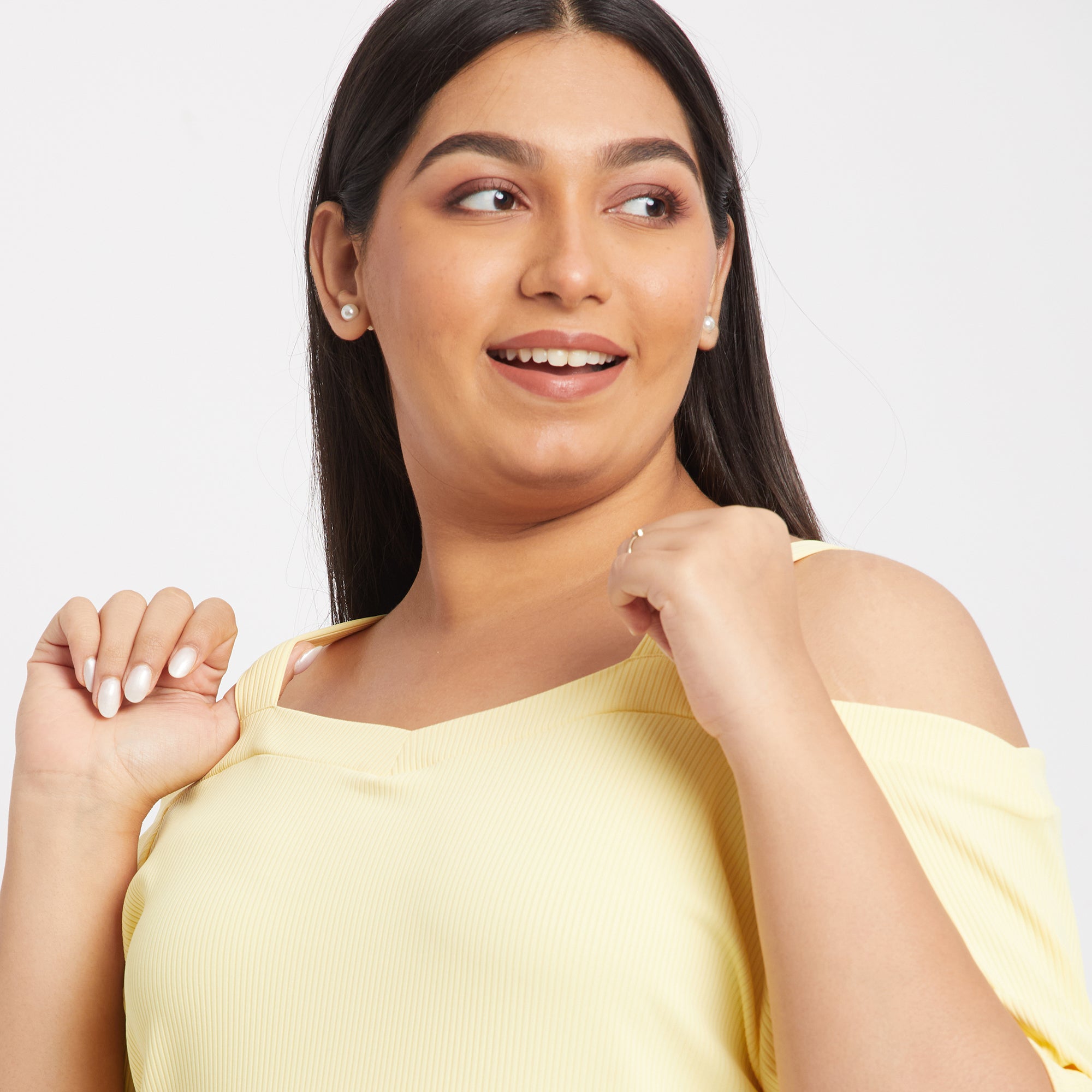Shoulder close-up of a yellow off shoulder knit top with a ribbed design from the front