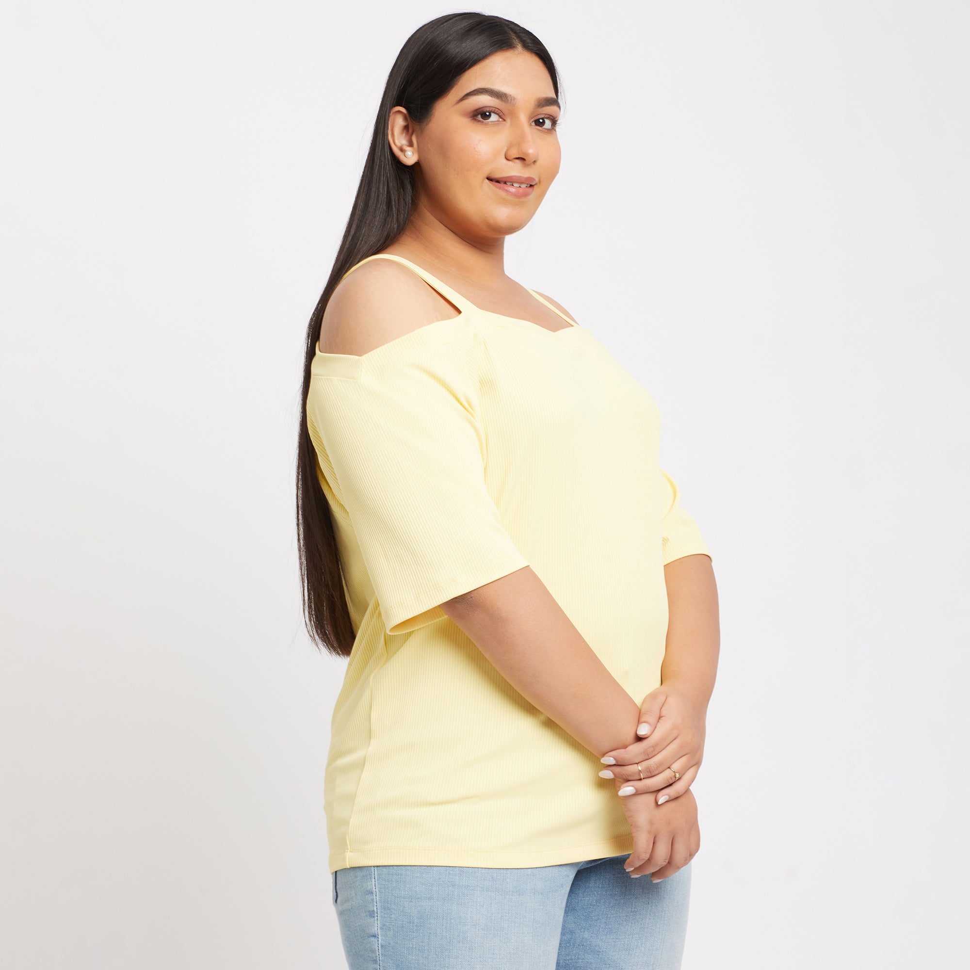 Side view of a yellow off shoulder knit top with a ribbed design 